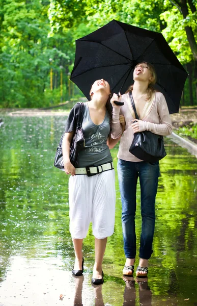 Две девушки радуются дождливой погоде — стоковое фото