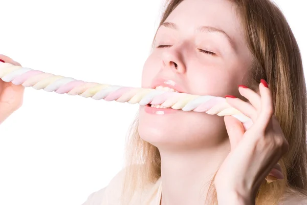 Junge Frau beißt in Süßigkeiten — Stockfoto