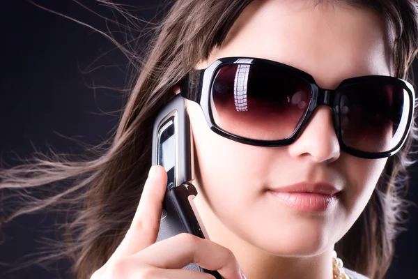 Женщина в солнечных очках с мобильным телефоном — стоковое фото