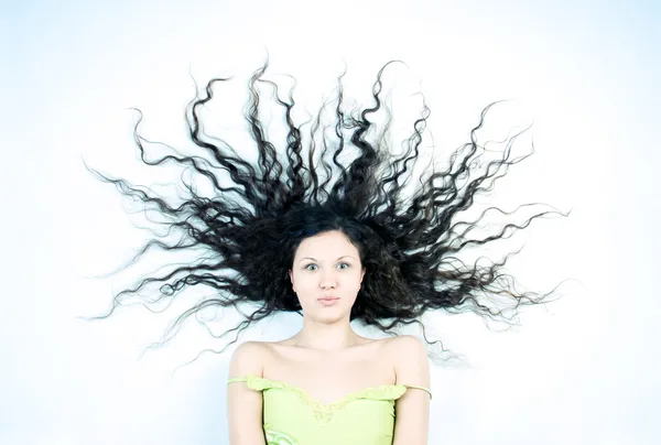 Junge Frau mit langen lockigen Haaren — Stockfoto