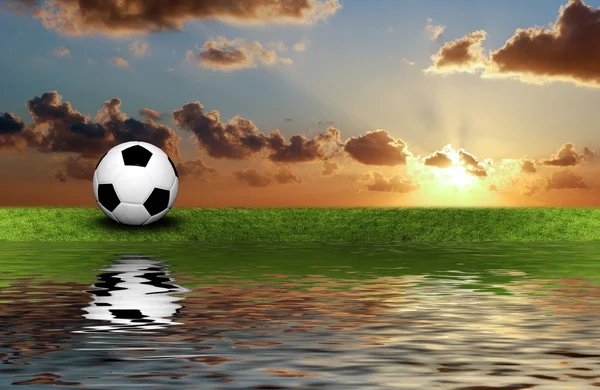 Voetbal op het groene gras met hemelachtergrond — Stockfoto