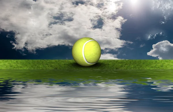 Tennis ball on the green grass with sky background — Stock Photo, Image