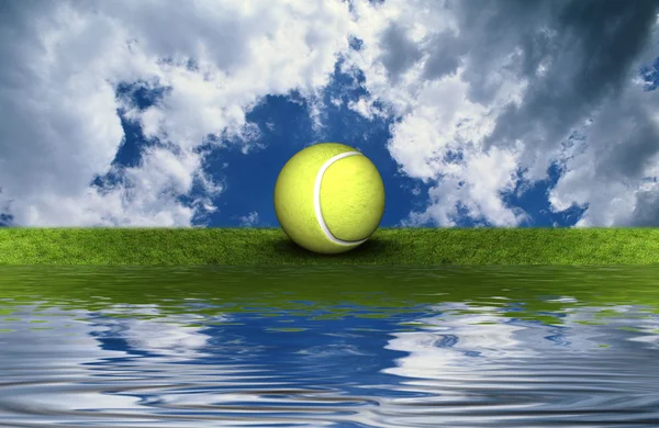 Tennis ball on the green grass with sky backgrou — Stock Photo, Image