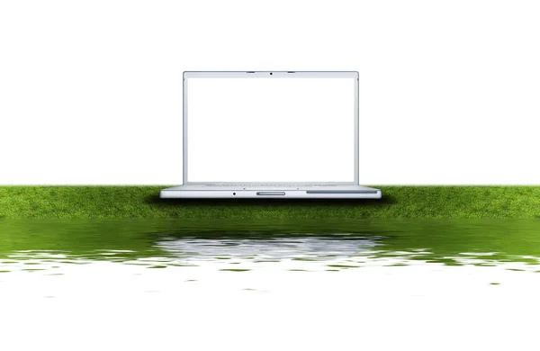 Prázdné přenosný počítač na zelené trávě — Stock fotografie