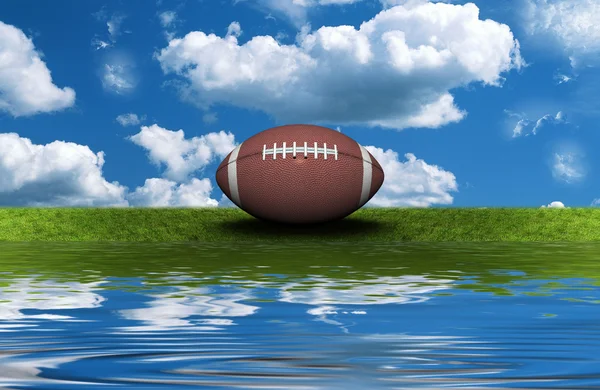 Football on the green grass with sky background