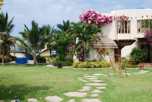 Tropischer Garten und Herrenhaus am Strand lizenzfreie Stockfotos