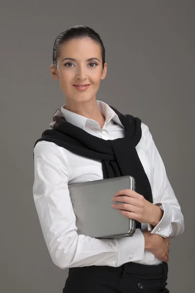 A bela mulher que segura o computador portátil — Fotografia de Stock