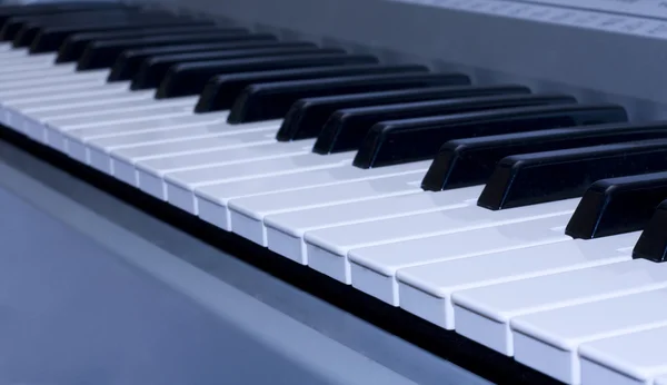 파란색 배경에 피아노 키보드 — 스톡 사진