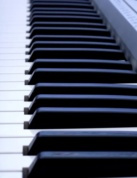 Teclado de piano sobre fondo azul — Foto de Stock