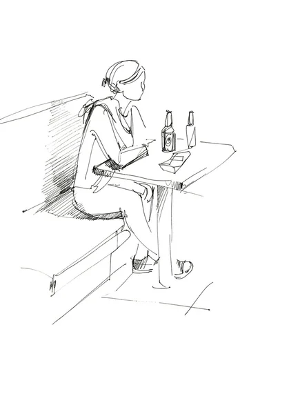 Девушка за столом и бутылка пива — стоковое фото