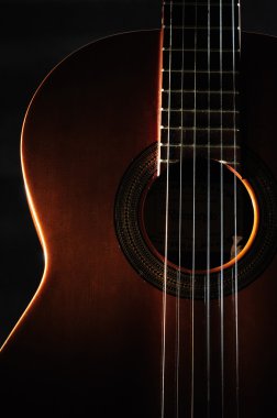 Six string guitar against a dark backgro clipart