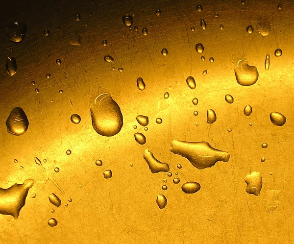Kapky vody na zlaté pozadí — Stock fotografie