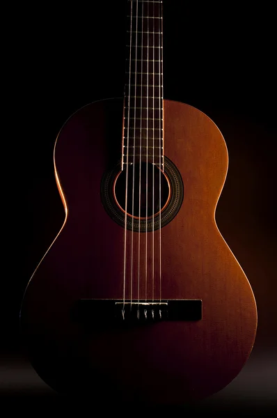 Guitarra de seis cordas contra um backgro escuro — Fotografia de Stock