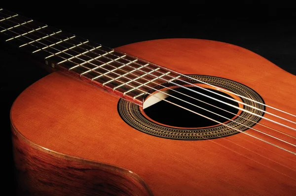 Guitarra de seis cuerdas contra un backgro oscuro Fotos de stock libres de derechos