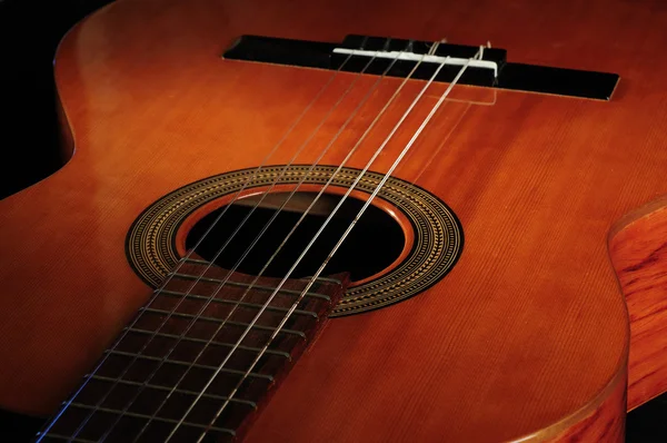 Guitarra de seis cuerdas contra un backgro oscuro Imagen de archivo