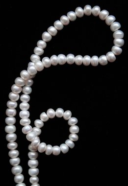 White pearls on the black silk as backgr clipart