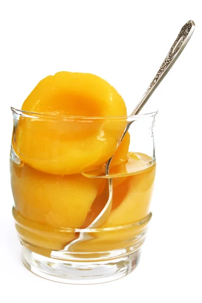 Halves of peaches in a sweet syrup in a — Stock Photo, Image