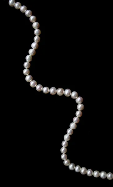 Vita pärlor på svart silke som bakgrunds — Stockfoto