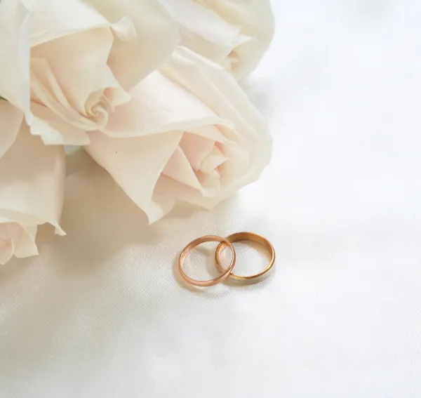 结婚戒指和玫瑰花作为背景 — 图库照片