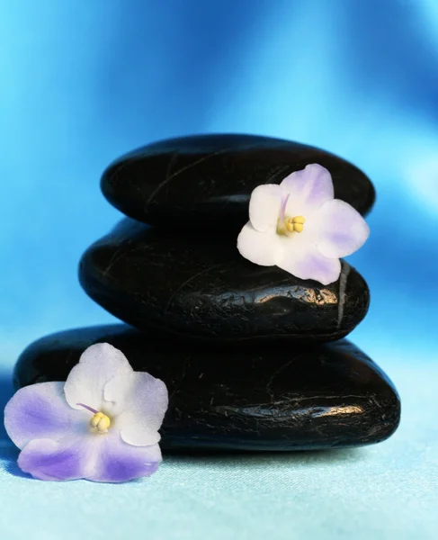 Spa kamienie z kwiatami na niebieski jedwabny bac — Zdjęcie stockowe