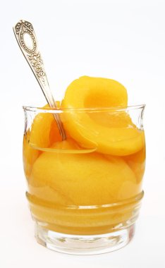 Peaches in a sweet syrup in a glass isol clipart