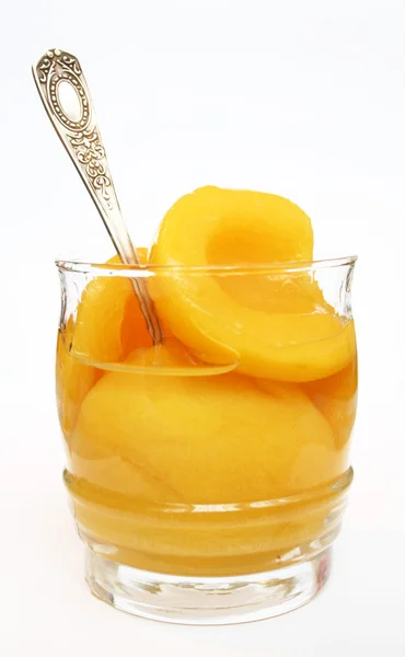 Perziken in een zoete stroop in een glas isol — Stockfoto