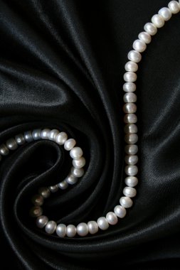 White pearls on the black silk as backgr clipart