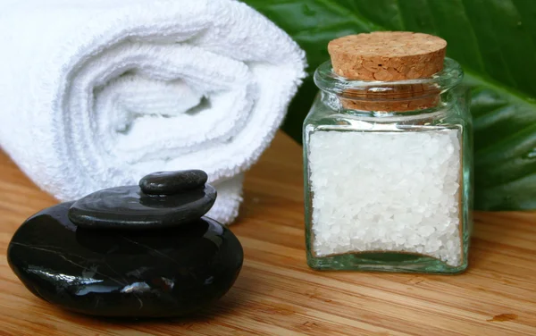 Білий рушник для ванни, пляшка морської солі і — стокове фото
