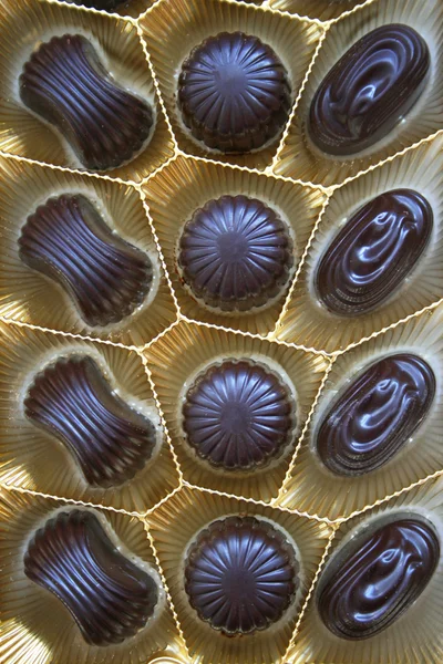 Deliciosos dulces de chocolate negro en caja a —  Fotos de Stock