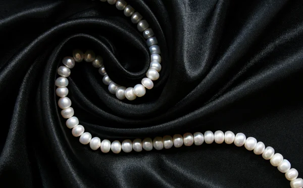 Білі перлини на чорному шовку як нарди Стокове Фото