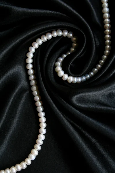 White pearls on the black silk — Stock Photo, Image