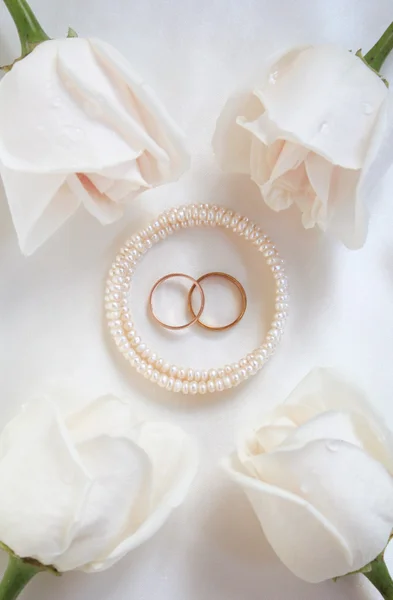 Обручальные кольца и розы в качестве фона — стоковое фото