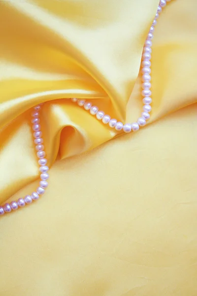White pearls on golden silk — Stock Photo, Image