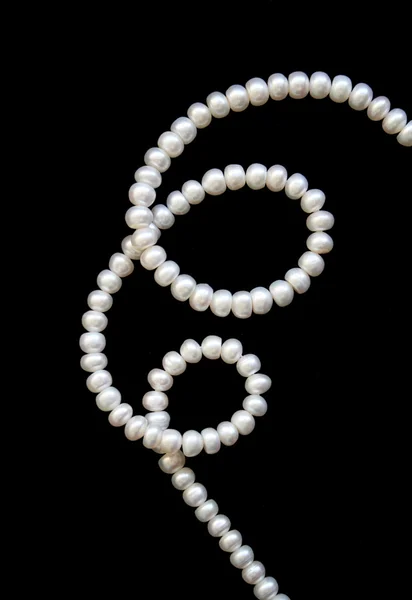 Perlas blancas sobre la seda negra — Foto de Stock