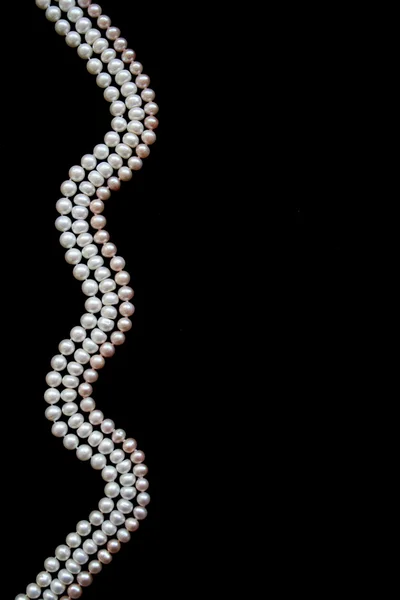 Vitt och rosa pärlor på svart silke — Stockfoto