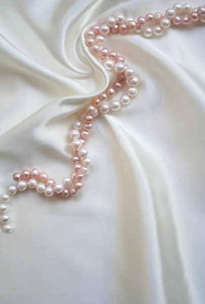 Vitt siden med vitt och rosa pärlor — Stockfoto