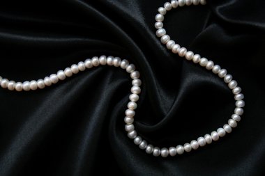 White pearls on the black silk clipart