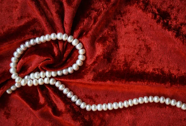 Białe perły na aksamitnej terakoty — Zdjęcie stockowe