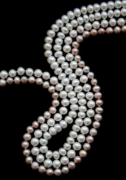 Perlas blancas y rosadas sobre la seda negra — Foto de Stock