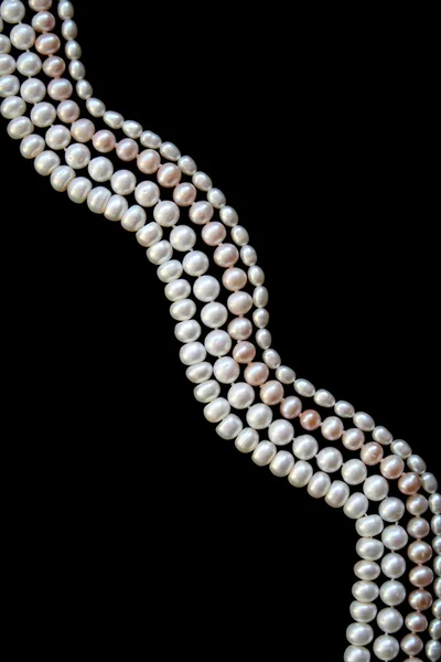 White and pink pearls on the black silk — Stock Photo, Image