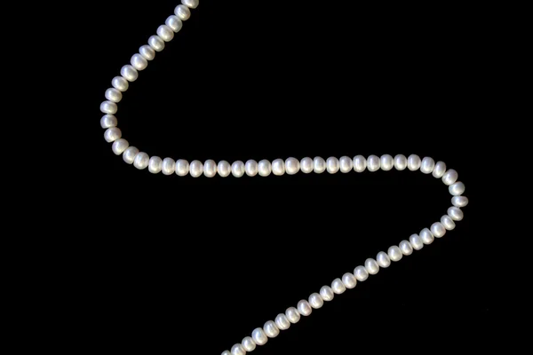Perlas blancas sobre la seda negra — Foto de Stock