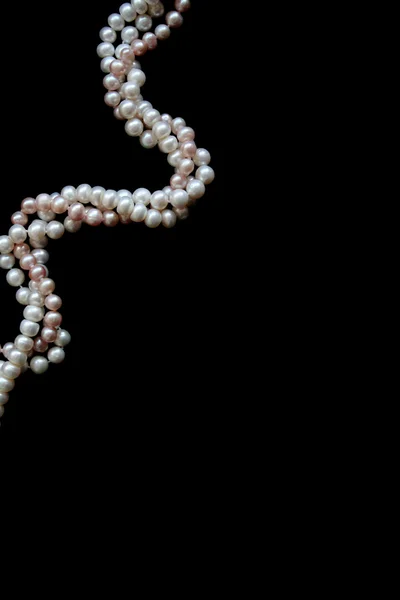 Bílé a růžové perly na černý samet — Stock fotografie