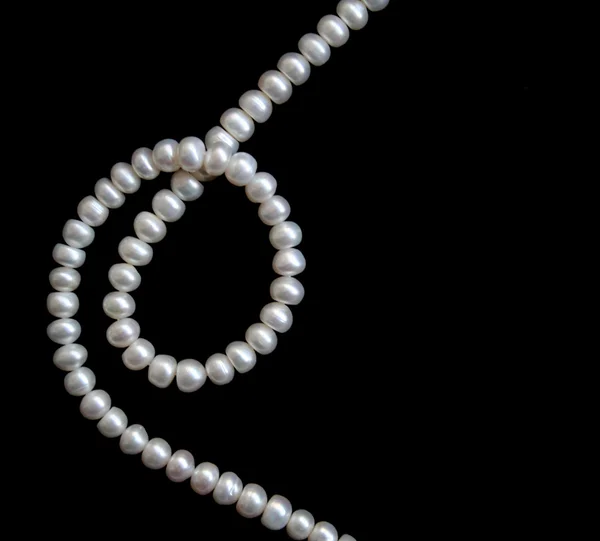 Vita pärlor på svart silke — Stockfoto