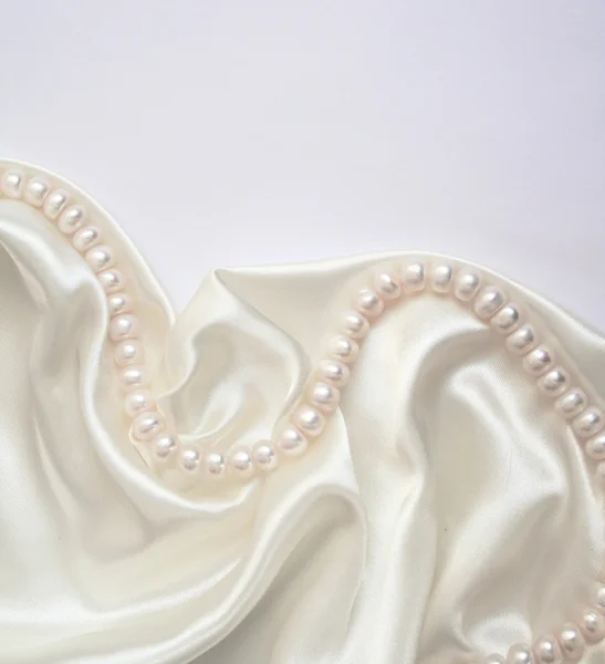 Glatte, elegante weiße Seide mit Perlen — Stockfoto