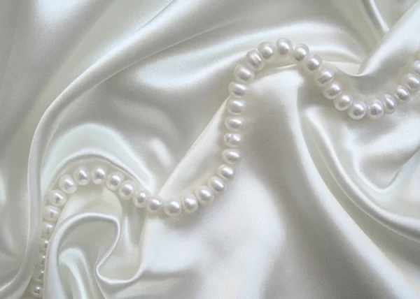 Гладкий элегантный белый шелк с жемчугом — стоковое фото