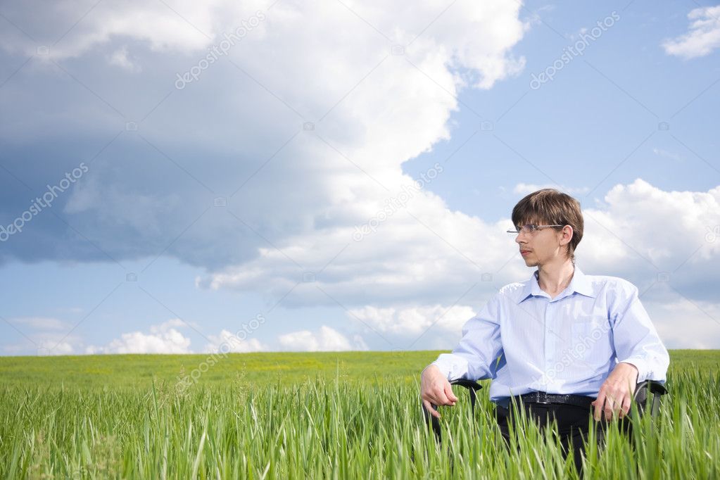 Businessman sitting on grassland
