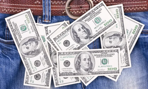 Many hundred dollar bills lying on jeans — Stock Photo, Image