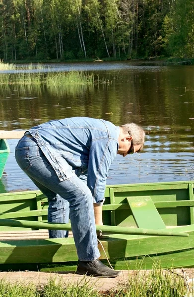 Een man unties een boot — Stockfoto