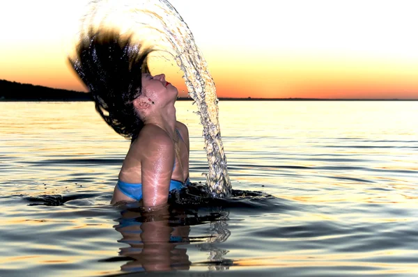 Menina salpicando ao pôr do sol — Fotografia de Stock