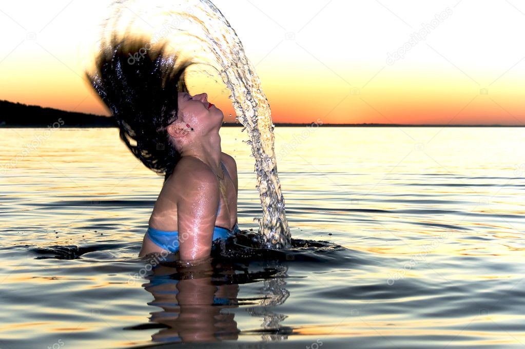 Girl splashing at sunset